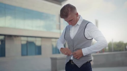 Stylish Man Buttons Vest Outside Modern Building