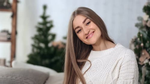 Woman Smiles Near Christmas Tree In Home