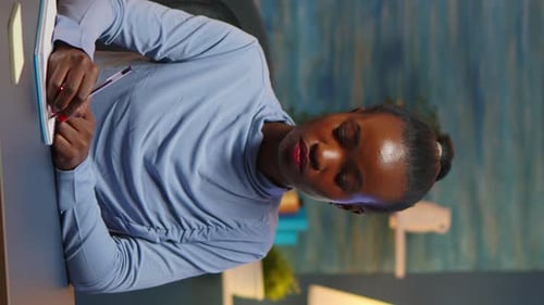 Adult Woman Writing in Notebook at Desk
