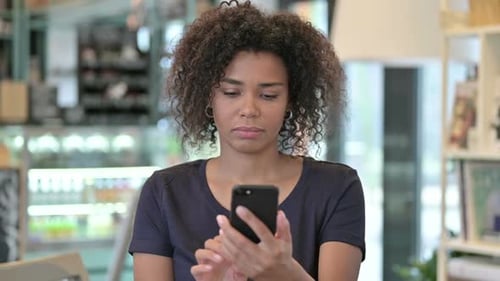 Young Adult Using Smart Phone in Cafe