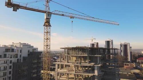 Vista aérea de grúas de torre alta y edificios de apartamentos residenciales en construcción