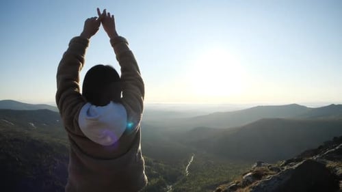 Woman Reaching Arms Out on Mountain at Sunrise