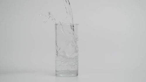 Cámara lenta de vertido de agua en vidrio transparente con hielo 1000 fps