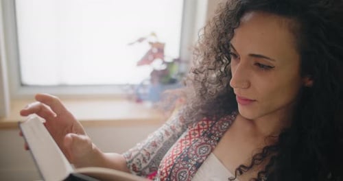 Woman with curly hair reading a book