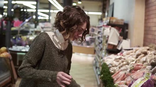 Pretty Young Beautiful Curly Hair Woman Buys Food in the Supermarket