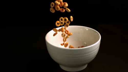 Circular cereal being poured into a bowl