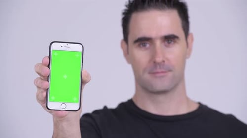 Man Holding Up Mobile Phone With Green Screen