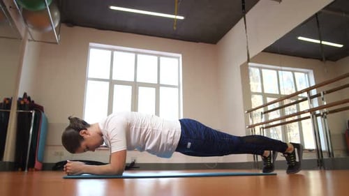 Woman Does Plank Exercise on Yoga Mat