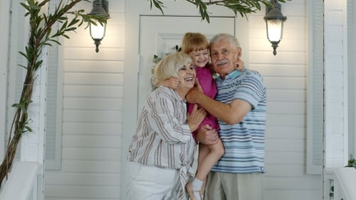 Grandparents Hugging Grandchild on White House Porch