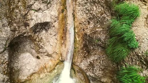 Luftaufnahme eines Mannes, der Canyoning und sich durch einen gleitenden Felsen wirft.