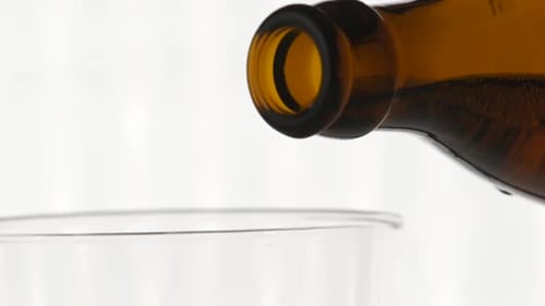 Bottle Pouring Beer into Glass Close Up