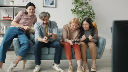 Family Playing Video Games Together at Home on Couch