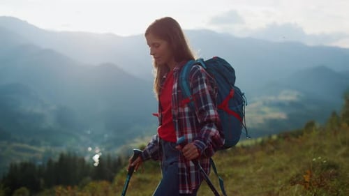 Female Hiker With Backpack On Green Mountain Slope