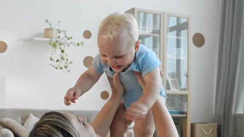 Mother Holds Infant Smiling in Sunny Home
