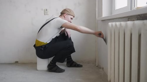 Young Adult Applies Compound to Wall Indoors