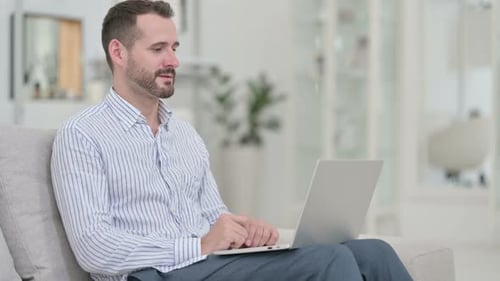 Man Video Chatting and Working on Laptop at Home