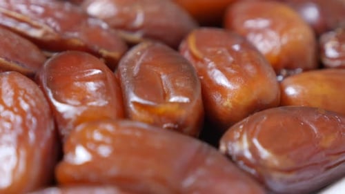 Exotic dates palm fruit on white reflective surface 4K 2160p 30fps UltraHD footage - Phoenix dactyli