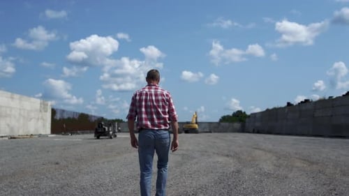 Agricultural Business Owner Inspecting Build Process with Backhoe Loader