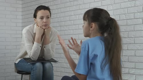 Woman Listens to Child in White Brick Room