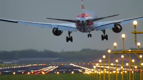 Passenger Plane Landing on Illuminated Runway at Night