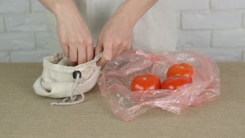 Tomatoes Placed Into Reusable Bag From Plastic Bag