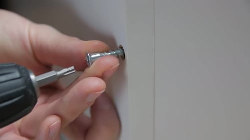 Screw Being Tightened into a White Panel