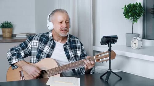 Adult Plays Guitar and Sings At Home