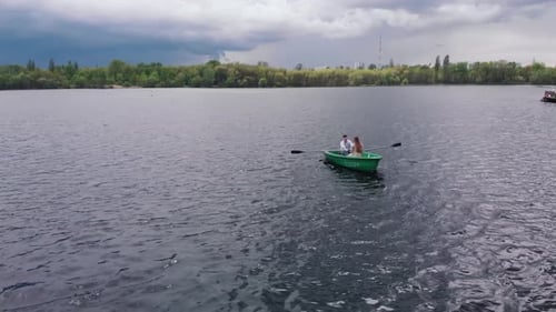 Aerial View of a Young Girl and a Man on a Rowboat on the River Near the Pier and a Panorama of the