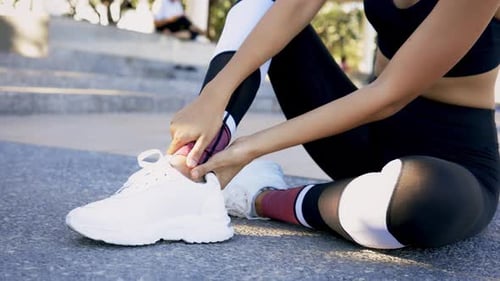 Woman Massaging Ankle After Workout