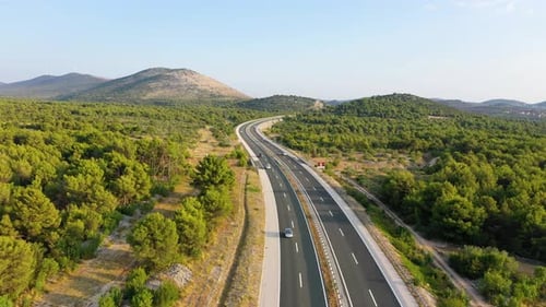 Aerial view on road. Highway through mountain valley. View from a drone.