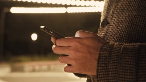 Man's Hands Using Smart Phone at Night