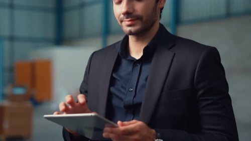 Factory Manager Using Tablet Computer in Warehouse or Factory