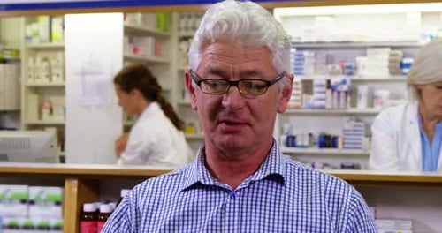 Customer holding prescription while checking medicine in pharmacy