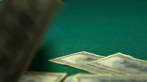 Many Hundred-Dollar Bills Falling to Green Table, Winning Big Jackpot, Close-Up