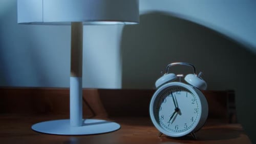 Hand Turns off Clock in Dark Bedroom at Night