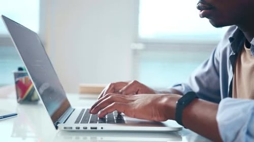 Close Up View of Male African American User Hands Typing on Laptop Keyboard