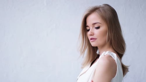Blond Woman Poses Elegantly in Studio
