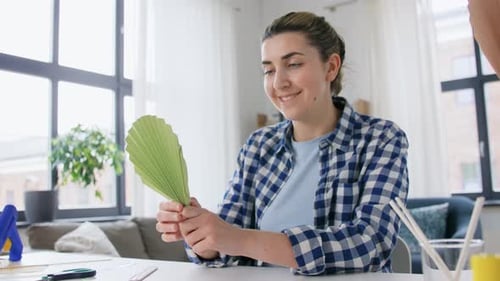 Woman Crafts a Paper Leaf at Home