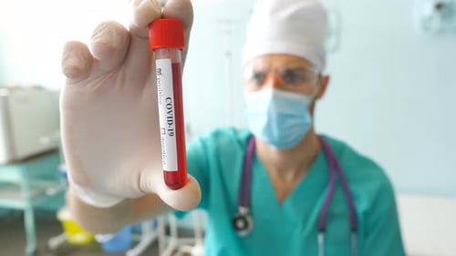 Doctor Holding Covid-19 Positive Test Tube