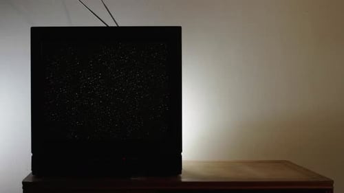 Vintage TV Showing Static in Dark Room