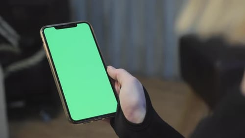 A Young Athletic Woman Holds A Smartphone in Her Hand, Shows A Green Chromakey Screen