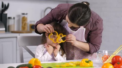 Mom and Daughter Having Fun Making Salad in Kitchen