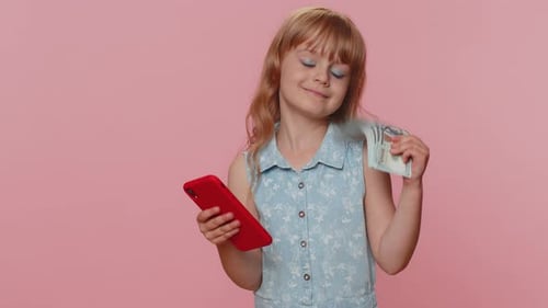 Child Using Phone and Holding Stack of Money