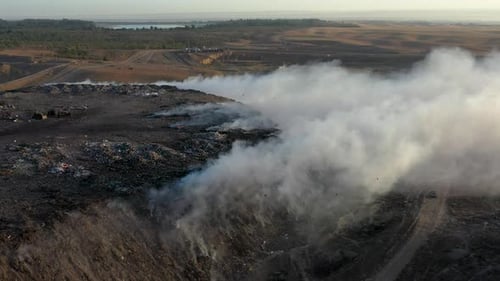 Aerial view of burning garbage pile in trash dump or landfill