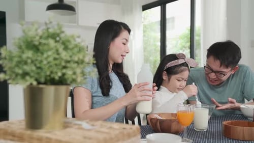 Family Eating Breakfast Together in Bright Home