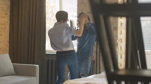 Playful Couple Dancing Together in Modern Apartment