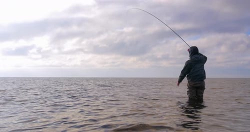 Man Standing Along the Sea Trying to Catch Sea Trout