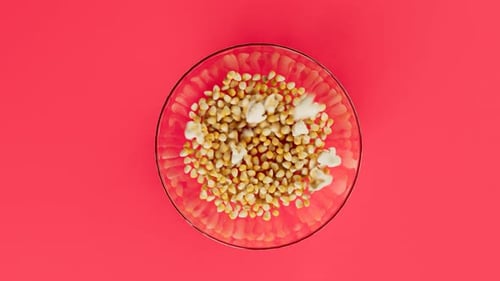 Dynamic Popcorn Popping Animation in Clear Bowl on Red Background