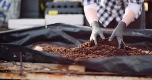 Working Hands Mixing Soil in Garden Setting