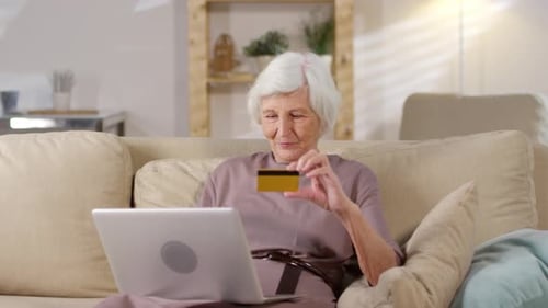 Senior Woman Using Laptop for Online Shopping at Home